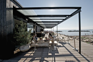 stor åben og overdækket terrasse med mange mennesker